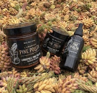 a jar of pine pollen on a bed of dried leaves